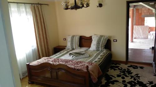 a bedroom with a bed in a room with a window at Pensiunea Adeluta in Călimăneşti
