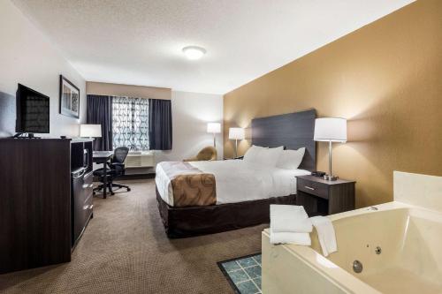 een hotelkamer met een bed en een bad bij Quality Inn in Clare