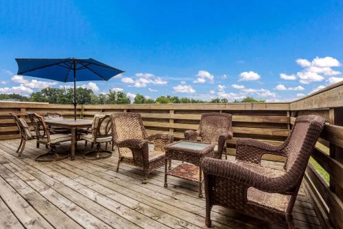 a deck with a table and chairs and an umbrella at Quality Inn in Clare