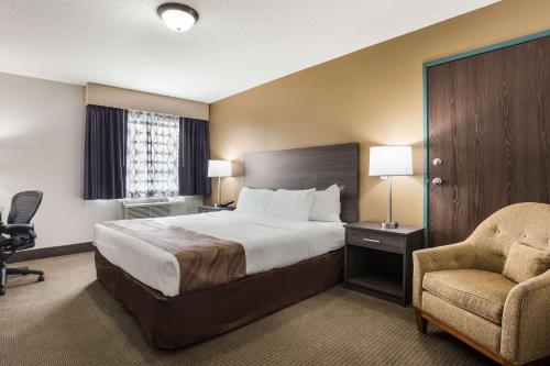 a hotel room with a bed and a chair at Quality Inn in Clare