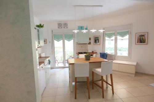 a kitchen with a wooden table and white chairs at Mediteranian Blue in Thessaloniki