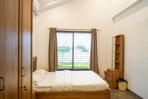 Schlafzimmer mit einem Bett und einem Fenster in der Unterkunft Nostalgia Villas in Silāri