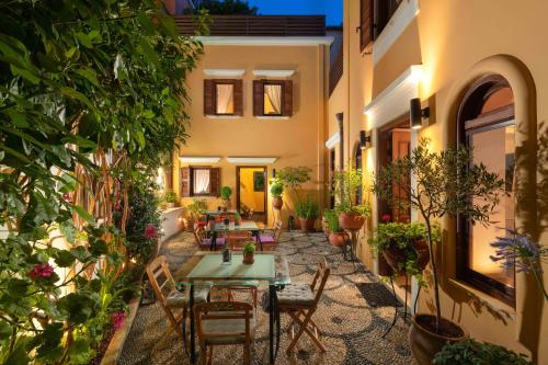 a courtyard with a table and chairs and plants at Rodos Niohori Elite Suites Boutique Hotel in Rhodes Town