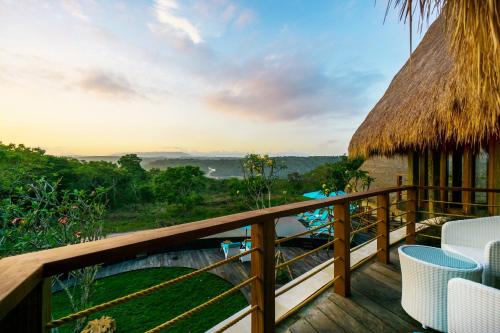 a deck with chairs and a view of the jungle at C-View Villas in Nusa Lembongan