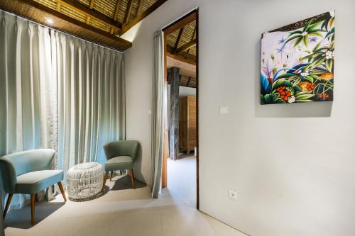 a room with two chairs and a painting on the wall at C-View Villas in Nusa Lembongan