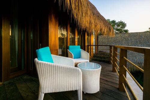 two chairs and a table on a deck at C-View Villas in Nusa Lembongan