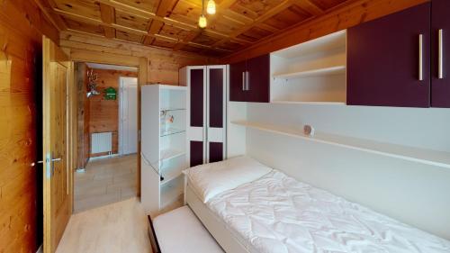 - une petite chambre avec un lit et un réfrigérateur dans l'établissement Mara MA3, à Blatten bei Naters