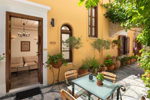 un patio al aire libre con mesa, sillas y macetas en Rodos Niohori Elite Suites Boutique Hotel en Rodas