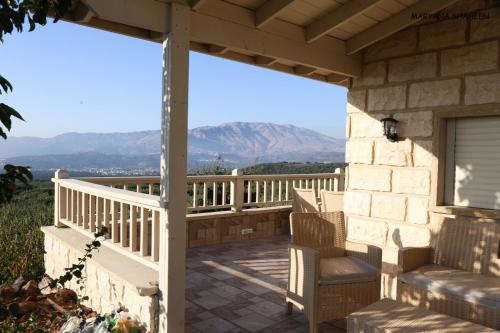 a porch with a view of the mountains at שקיעת הדובדבן in Odem
