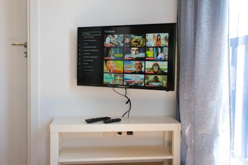a flat screen tv sitting on top of a white table at White Arches Apt #1 by TrulyCyprus in Limassol