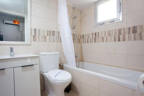 a bathroom with a toilet and a tub and a sink at White Arches Apt #1 by TrulyCyprus in Limassol