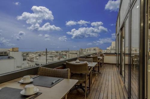 a balcony with tables and chairs and a view of a city at Hotel Venera Istanbul Old City in Istanbul