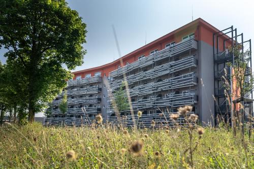 een appartementencomplex voor een veld bij Augsburg Hotel Sonnenhof in Gersthofen