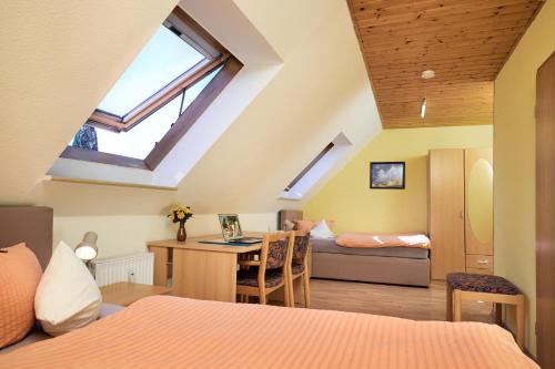 a bedroom with a bed and a desk in a room at Regenbogen-Appartement in Bad Krozingen