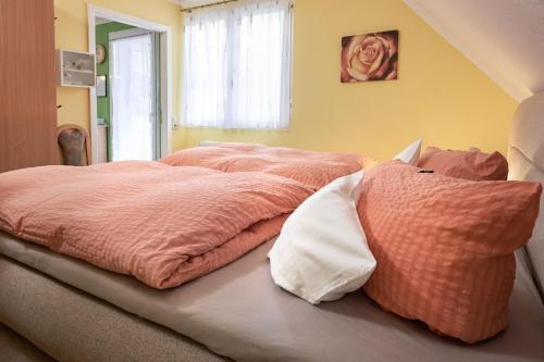 a bed with pink blankets and pillows in a room at Regenbogen-Appartement in Bad Krozingen