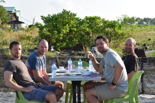 a group of men sitting at a table at Finimas Residence in Thimarafushi