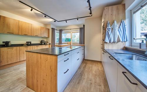 eine große Küche mit weißen Schränken und einem Waschbecken in der Unterkunft Chalet Fuchsbau in Viehhofen