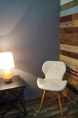 a white chair next to a table with a lamp at Hostel Privado in Puerto Princesa City