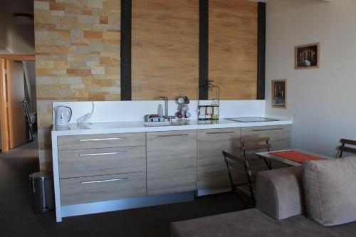 a kitchen with a counter with a sink and a table at Apartman Vlada b14 in Kopaonik