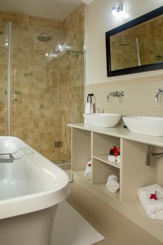 a bathroom with two sinks and a tub and a shower at IL Castello in Clarens