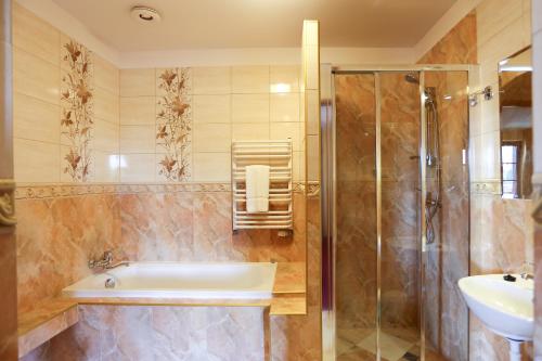 ein Bad mit einer Badewanne, einem Waschbecken und einer Dusche in der Unterkunft EdMar in Malbork