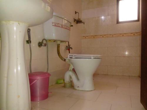 a bathroom with a toilet and a sink at Mufis Homestay, Emerald Compound, New Palam Vihar-2 in Gurgaon