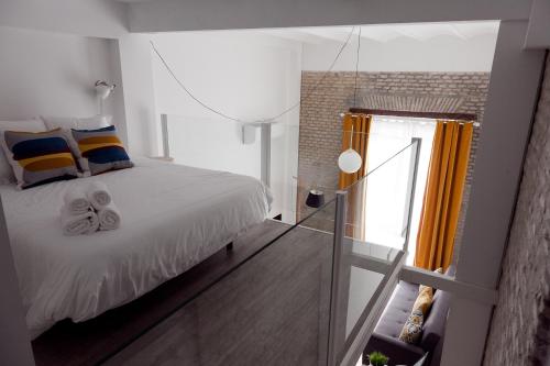 セビリアにあるGoToSeville FERIA APARTMENTSのベッドルーム1室(ベッド1台、ガラス窓付)