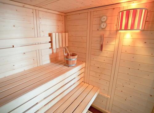 a wooden sauna with a bucket in it at Hôtel Club mmv Les Bergers **** in L'Alpe-d'Huez