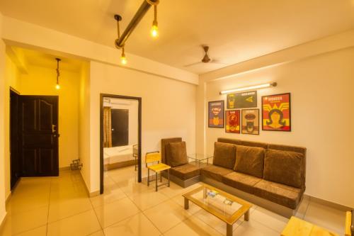 a living room with a couch and a table at La Maison Charu in Puducherry