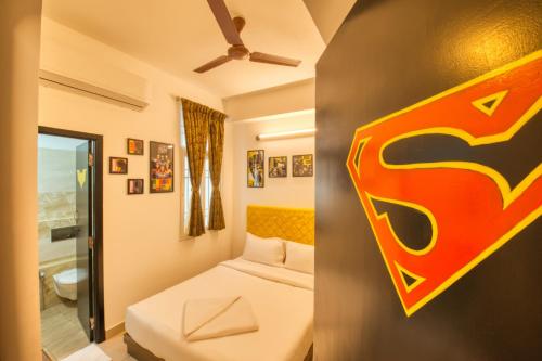 a bedroom with a bed and a sign on the wall at La Maison Charu in Puducherry