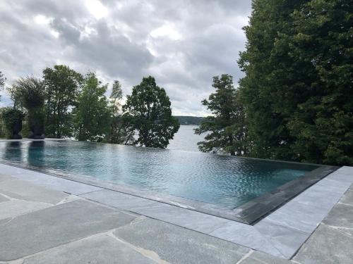 a swimming pool with a view of a lake at Villa Lovik in Lidingö