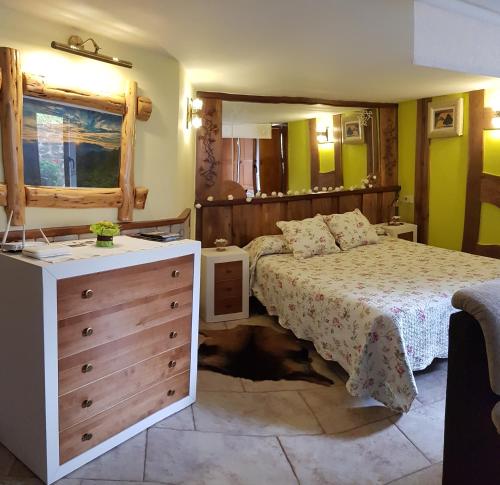a bedroom with a bed and a dresser in it at Apartamentos La Condesa in Valmeo
