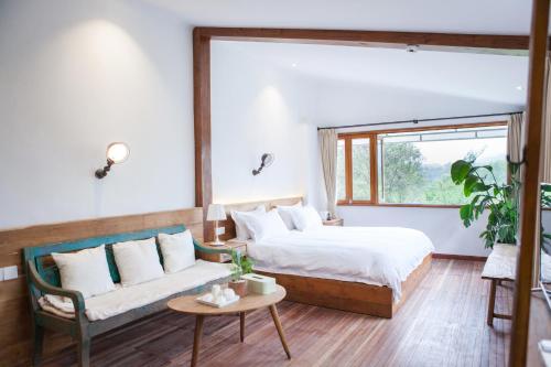 杭州的住宿－杭州蜜桃小院，一间卧室配有一张床、一张沙发和一个窗口