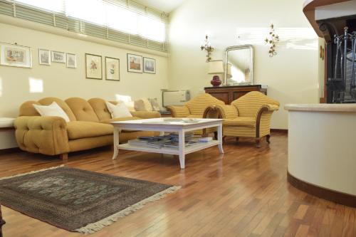 a living room with a couch and a table and chairs at Villa dei Gelsomini, Residenza nel verde in Viterbo