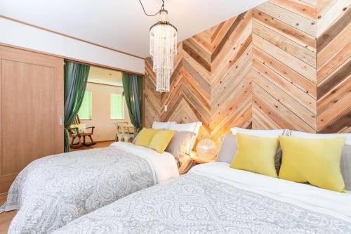 MetaにあるOkinawa Seaside Besso5の木製の壁のベッドルーム1室(ベッド2台付)