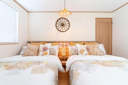 a bedroom with two beds and a chandelier at Okinawa Seaside Besso5 in Onna