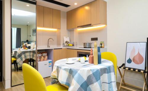 a kitchen with a table and yellow chairs in a kitchen at Citadines Gaoke Liangjiang Chongqing in Chongqing