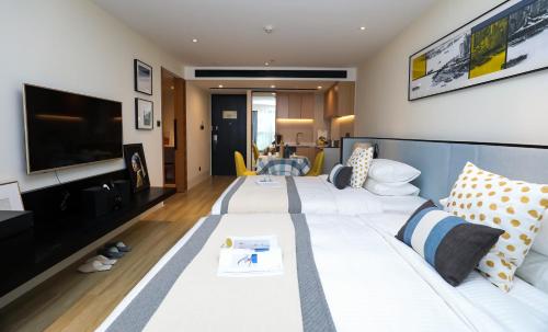 a living room with a white couch and a tv at Citadines Gaoke Liangjiang Chongqing in Chongqing