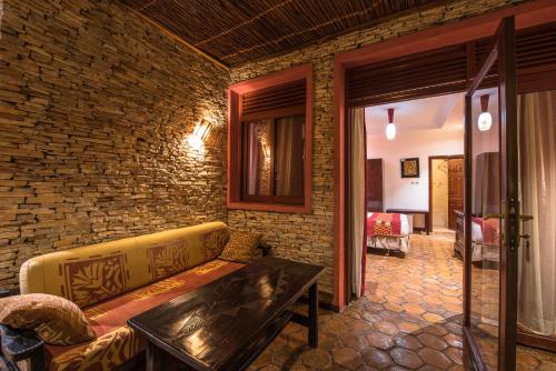 a living room with a couch and a brick wall at Inside Afrika Boutique Hotel in Kigali