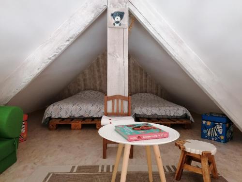 a room with two beds and a table in a attic at logement en campagne in Landemer
