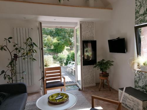 a living room with a door open to a patio at logement en campagne in Landemer
