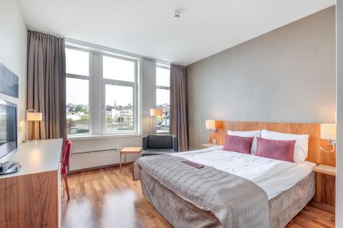 a hotel room with a large bed and a desk at Quality Hotel Residence in Sandnes