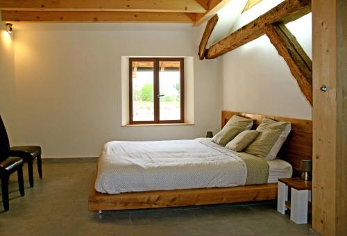 a bedroom with a bed and a window at ferme du bois joli in Marigny