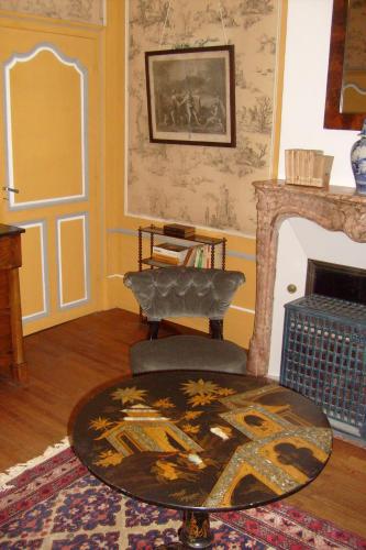 a living room with a chair and a fireplace at Château De Serrigny in Ladoix Serrigny