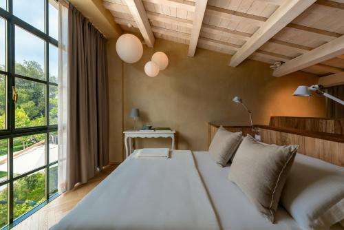 een slaapkamer met een groot bed en een groot raam bij Rambaldi Apartments Casa nr 4 Garden in Bardolino