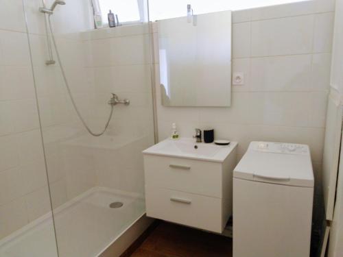 a white bathroom with a sink and a shower at Le Saint Jaumes parking inclus in Montpellier