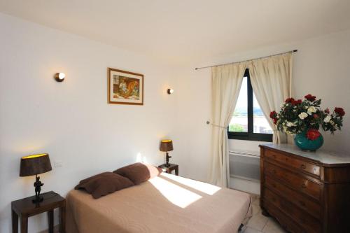 - une chambre avec un lit, une commode et une fenêtre dans l'établissement Terracorse, à Figari