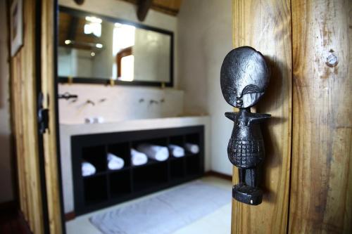 eine Badezimmertür mit einer Statue einer Person in der Unterkunft Tidimalo Lodge in Rustenburg