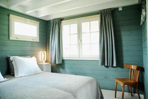 Dormitorio azul con cama y ventana en Buitenhuisje B&B De Veldweg, en Heerde