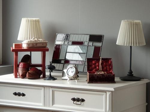 a white dresser with two lamps and a mirror at B&B 't Merthoes in Susteren